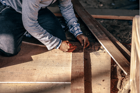 Skilled builder precisely marking timber, symbolizing meticulous craftsmanship and professional building work.