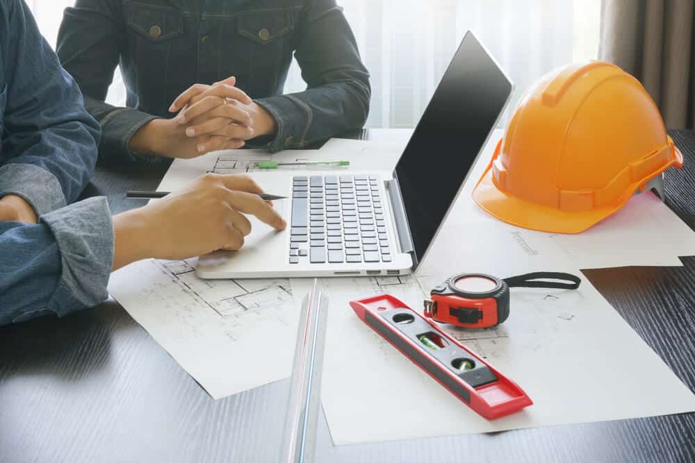 Tech-savvy Wellington based Smartway Builders team using a laptop to plan and manage a construction project.