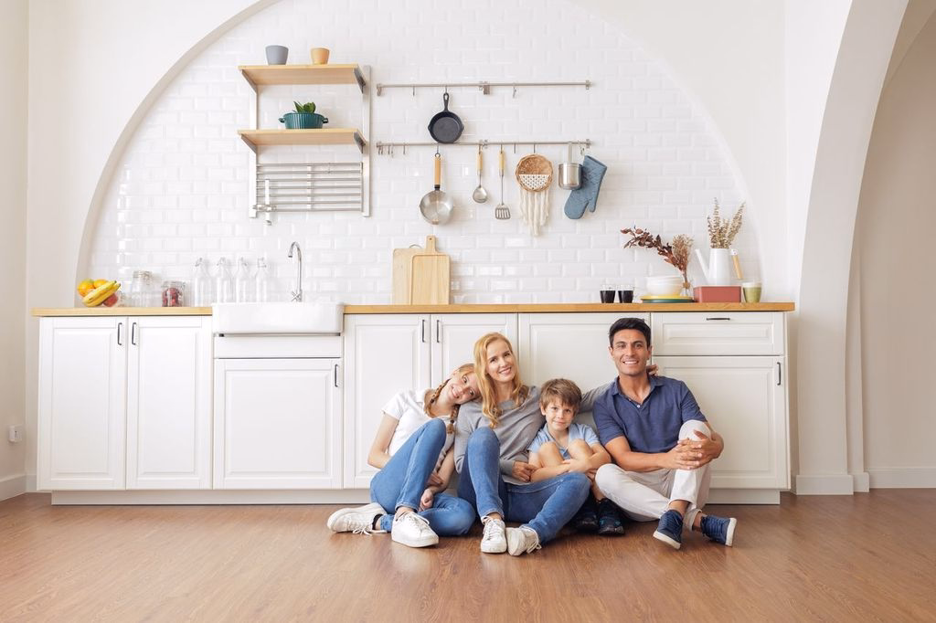 Joyful family sitting in their new kitchen representing the positive experience of building with Smartway Builders.